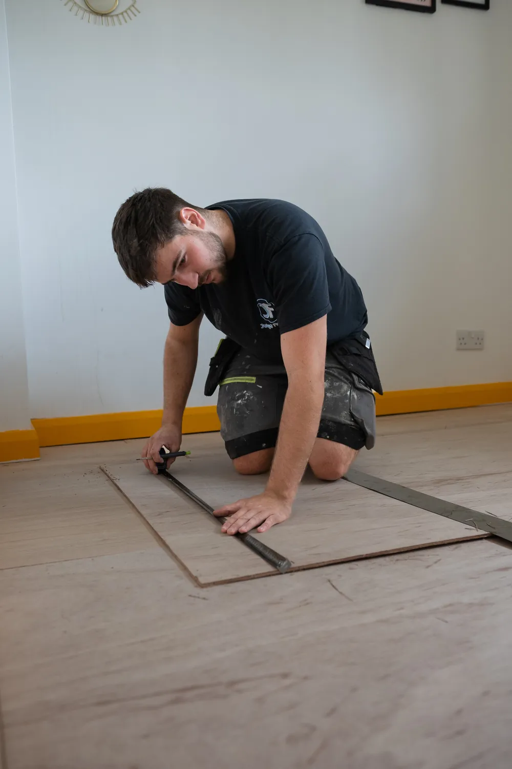 Plywood being fixed down over old floorboards before the new floor